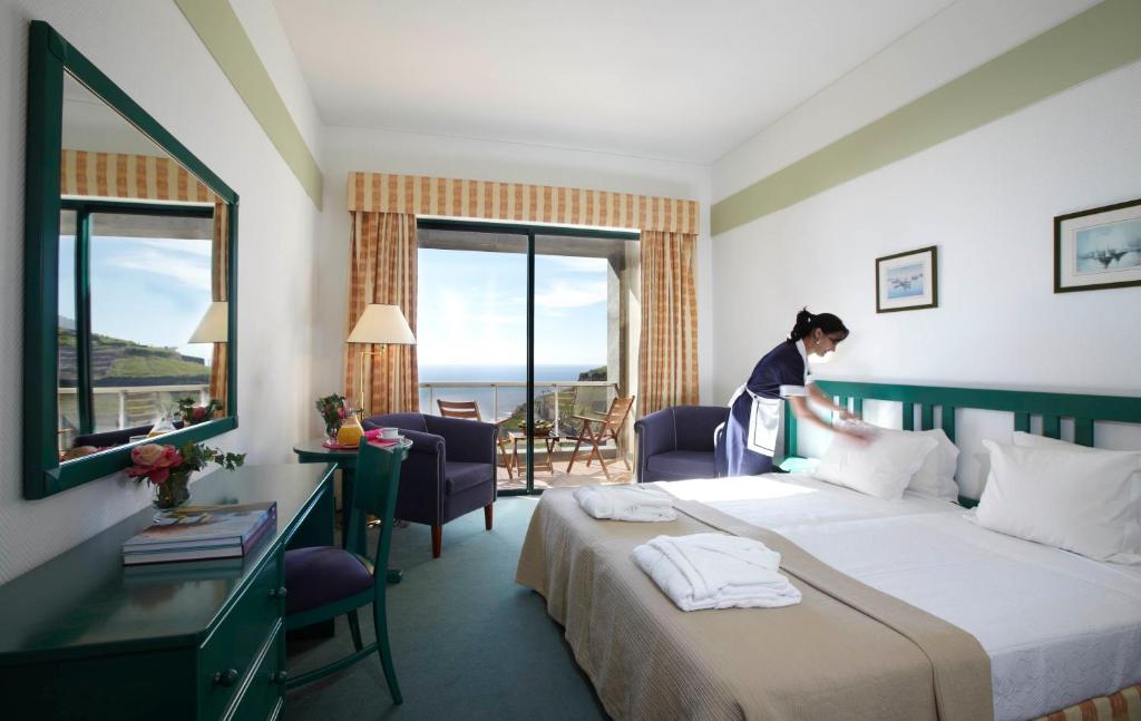 een vrouw in een hotelkamer met een bed bij Hotel Escola in Funchal