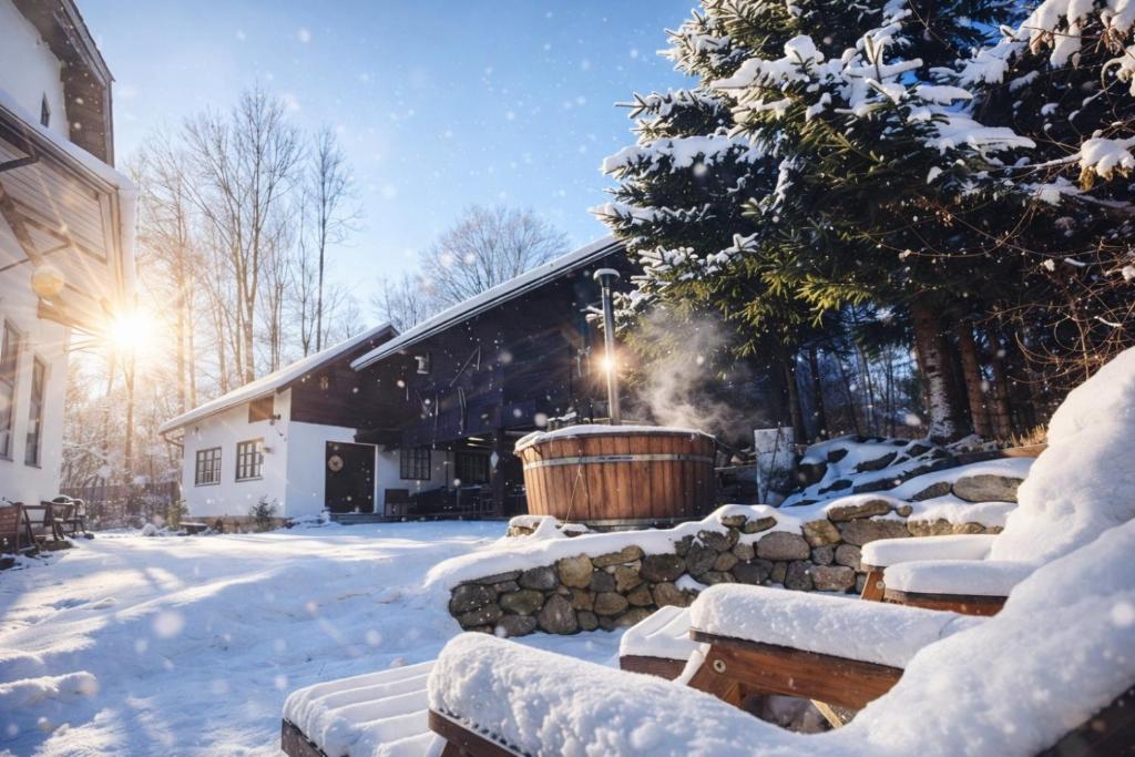 a hot tub in a yard covered in snow at Chalupa Skála 1827 in Skála