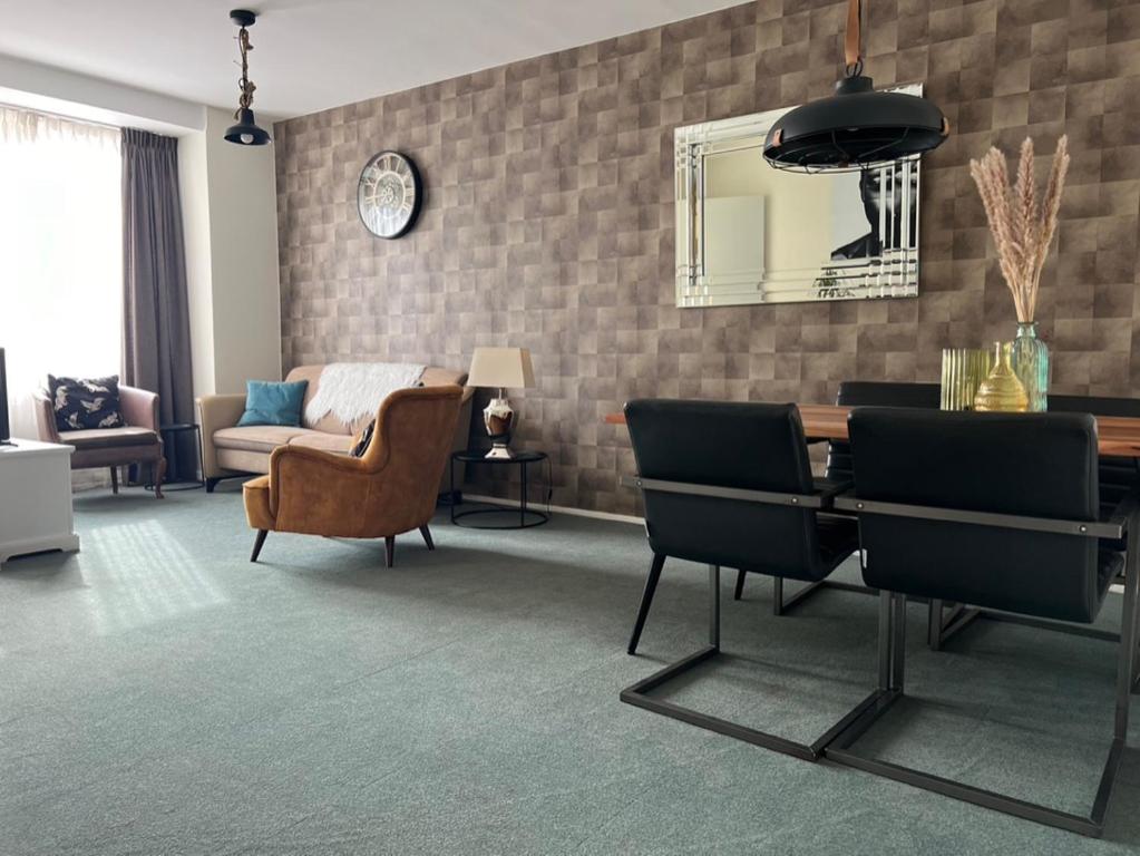 a living room with a table and chairs and a couch at Shoreline Apartment Katwijk in Katwijk aan Zee