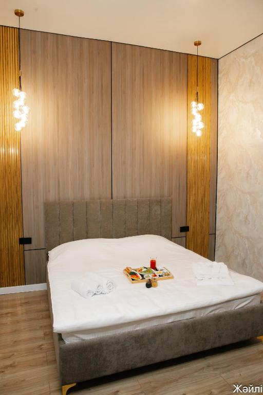 a bedroom with a bed with white sheets at Zhaily Hotel in Semey
