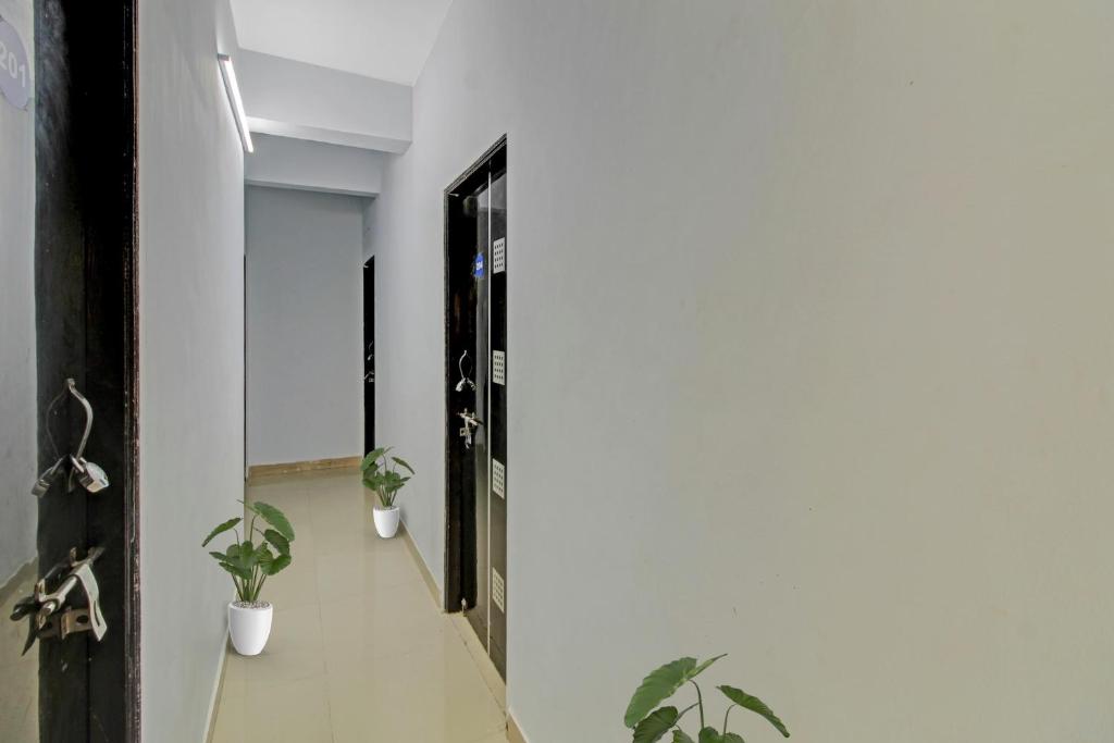 een hal met twee potplanten en een deur bij Hotel O Western Avenue Pune Formerly Happy Stay in Méribel Village