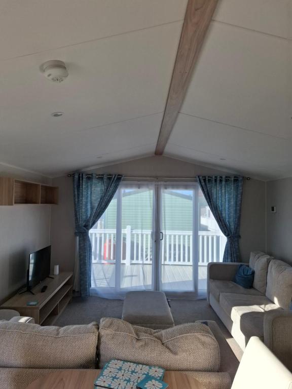 a living room with a couch and a tv at Life is Adventure in Great Clacton