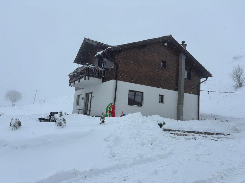 a building with snow on the ground in front of it at Dealul Craiului in Şirnea