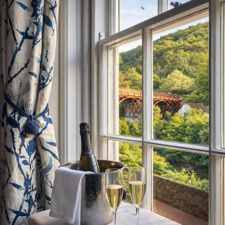 a bottle of wine sitting on a table next to a window at Ironbridge View Townhouse - WINNER 2026 UK MOST PICTURESQUE SELF-CATERING HOLIDAY HOME & 2026 SELF-CATERING ACCOMMODATION OF THE YEAR in Ironbridge