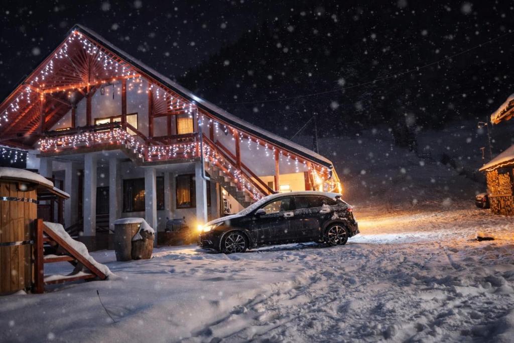 un'auto parcheggiata di fronte a una casa con luci natalizie di La Casieru a Bilbor