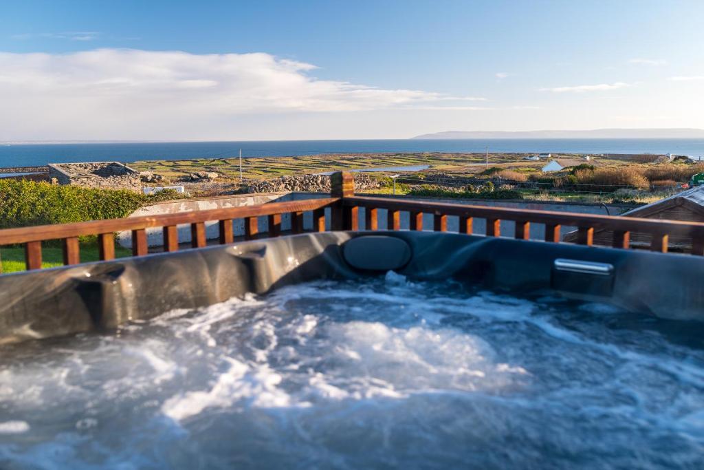 a hot tub on a deck with water at Port Aran House in Kilronan