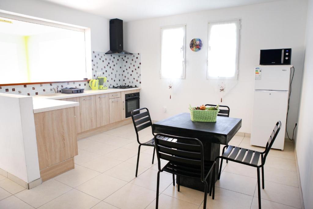 a kitchen with a black table and chairs in it at Kaïvivi in Le Marin