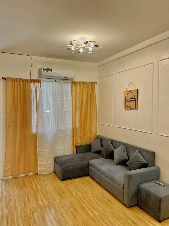 ein Wohnzimmer mit Sofa und Deckenventilator in der Unterkunft Primari Haven in Bantinguil