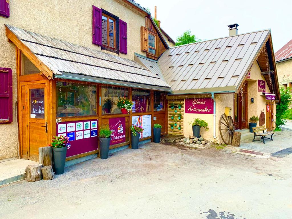 a store front of a building with flowers in pots at Gite Le Rebanchon in Le Monêtier-les-Bains