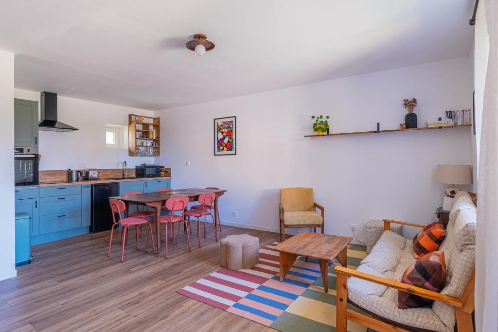 a kitchen and living room with a table and chairs at La Garencière - Les Fleurs in Champfleur