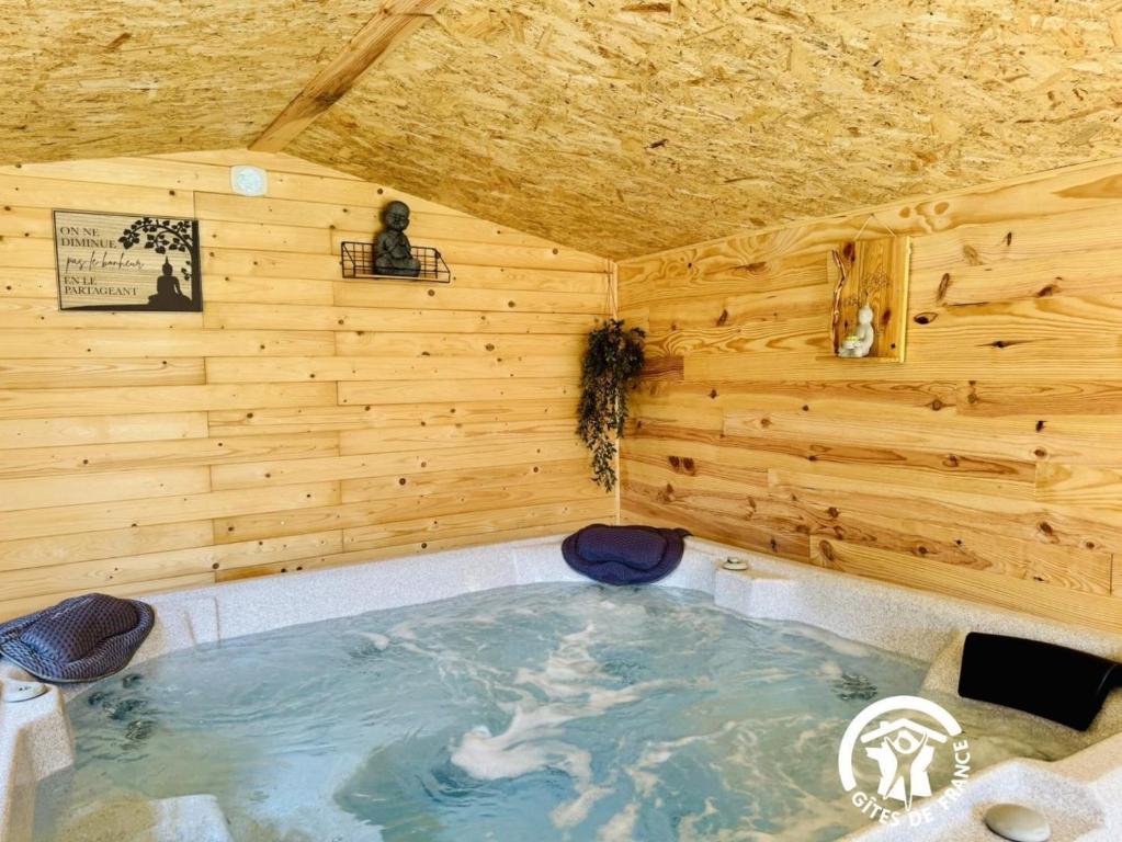 a jacuzzi tub in a room with wooden walls at La douce echappée in Trèbes