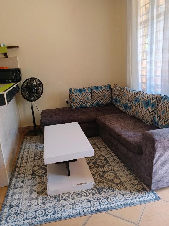 a living room with a couch and a table at milina homes in Ukunda