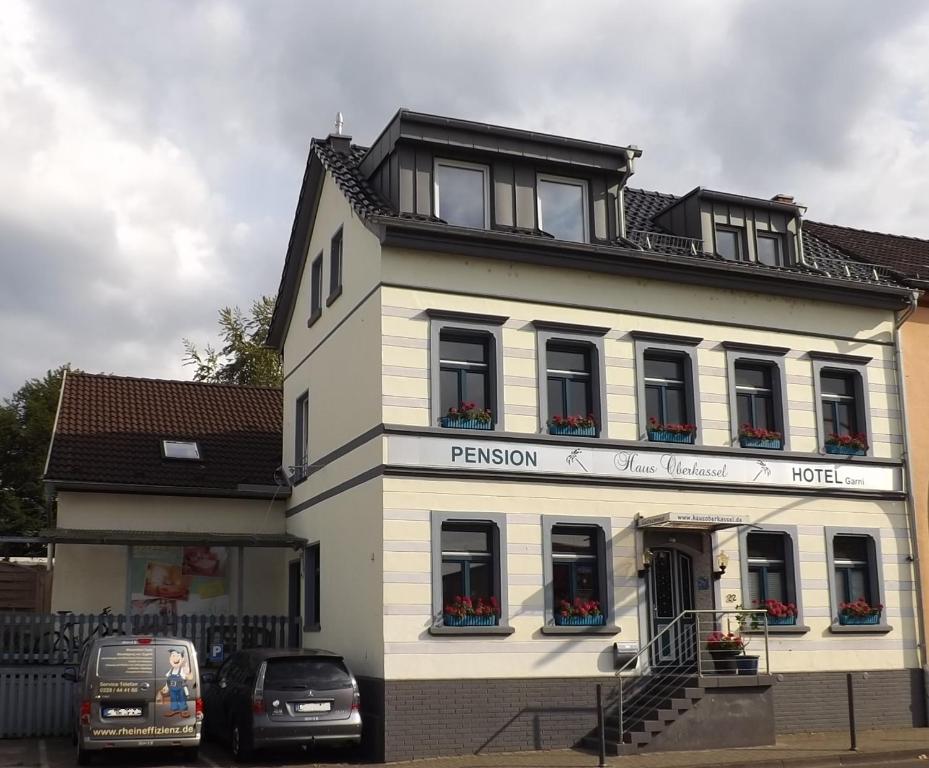 een wit gebouw met auto's ervoor geparkeerd bij Haus Oberkassel in Bonn