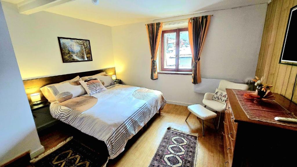 a bedroom with a bed and a desk and a window at Maison Cavalese - Polar Express in Cavalese