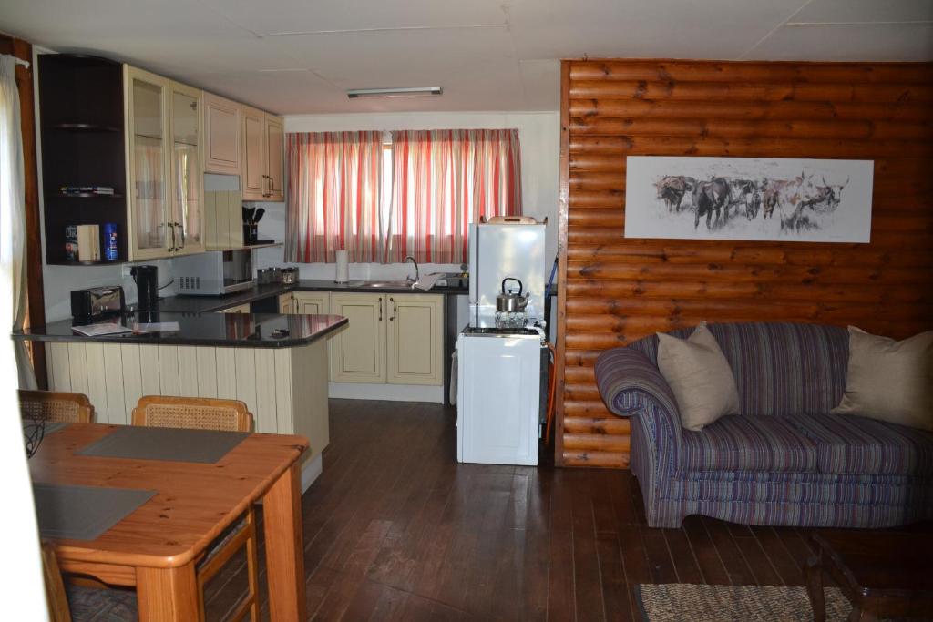 a kitchen and living room with a couch and a refrigerator at Trout Ways in Waterval Boven