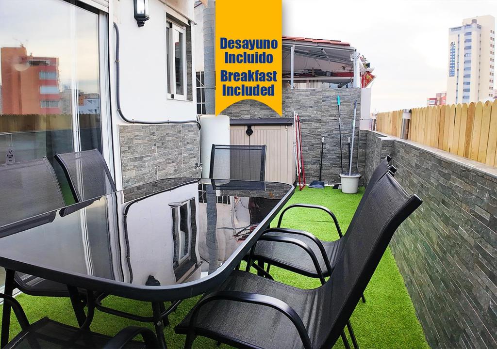 een tafel en stoelen op het balkon bij Apartalux Ático Jaime I in Benidorm