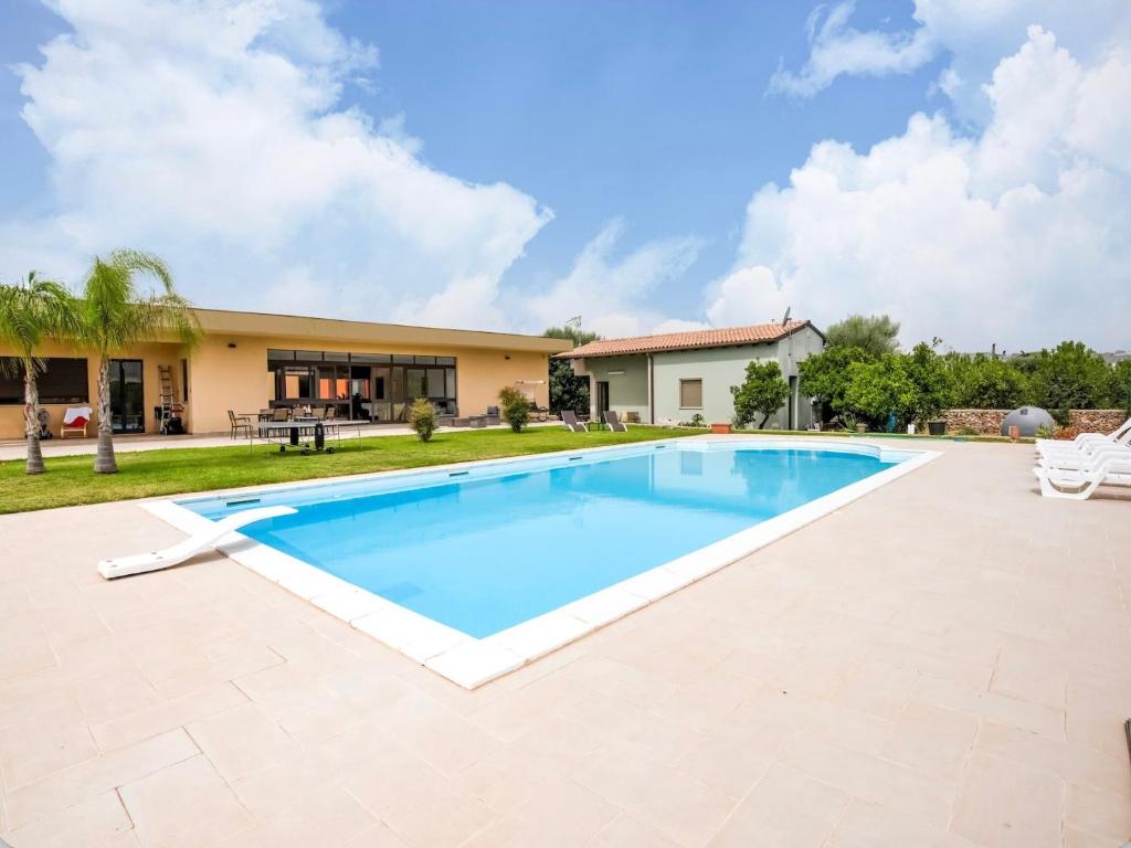 a swimming pool in front of a house at Villa Germano con piscina in Solarino