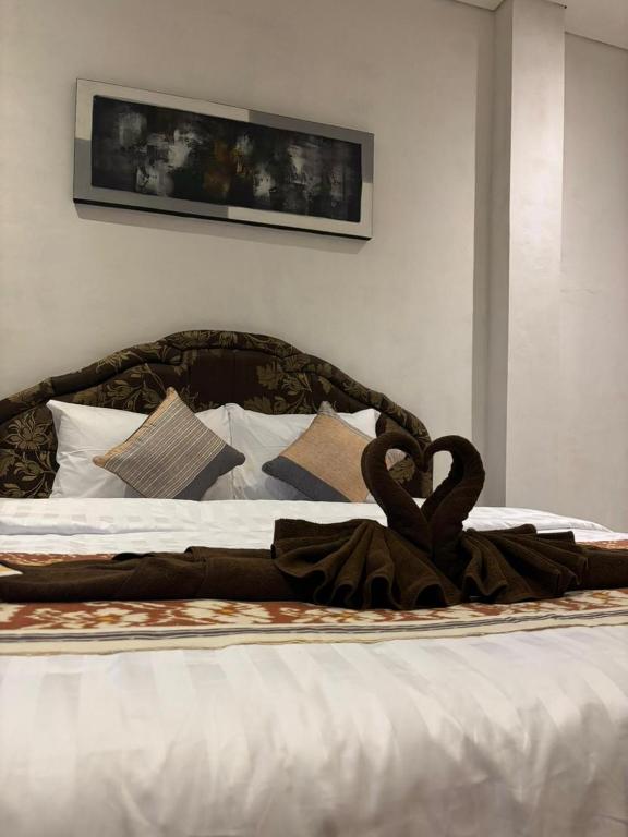 a bed with a blanket with swans on it at Rumah Ramah Ubud in Ubud