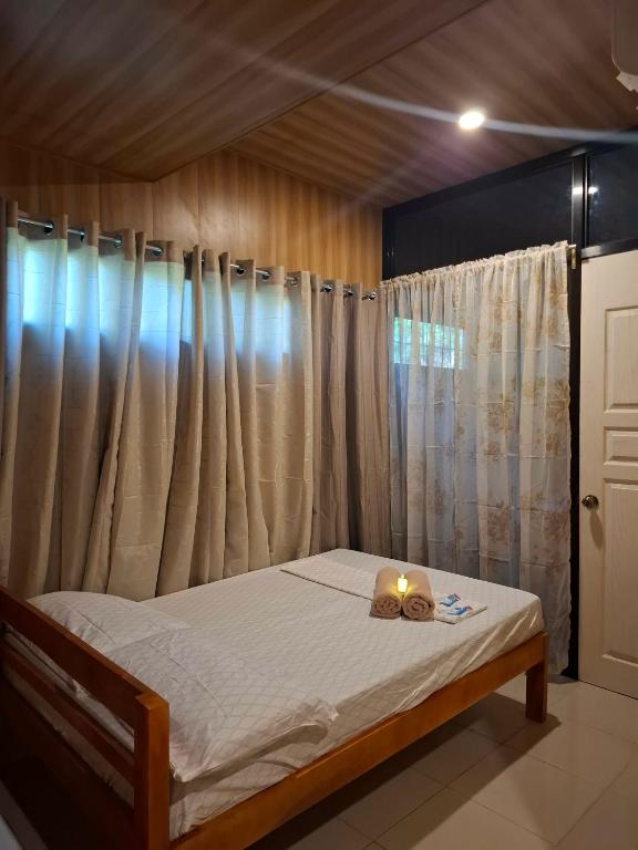 a bedroom with a bed with a candle on it at Queenbee's Place in Tagum