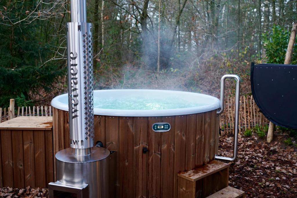 vasca idromassaggio in un cortile accanto a una recinzione di Unieke Yurt in het bos met jacuzzi en sauna a Erp