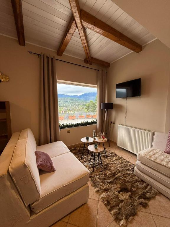 a living room with a couch and a large window at Κτήμα Παππά Ρετιρέ in Livadeia