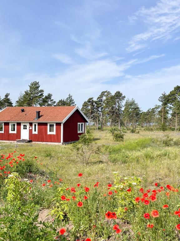 a red barn in a field of flowers at Nobel Cabins - Furillen in Lärbro
