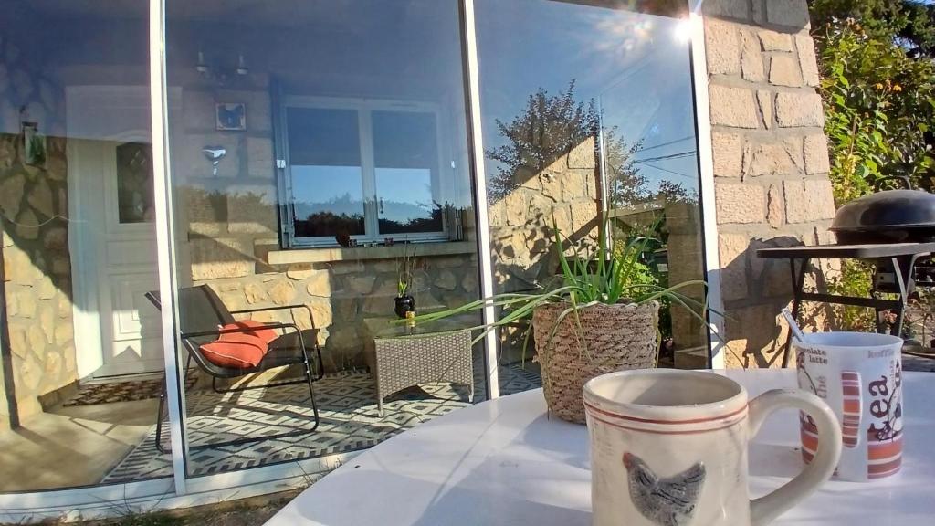una tazza di caffè seduta su un tavolo sul patio di Grand Studio Côté Jardin a Saint-Sernin