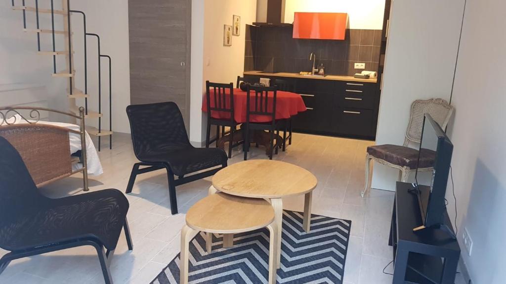 a room with chairs and a table and a kitchen at Studio charmant avec jardin in Saint-Rémy-de-Provence