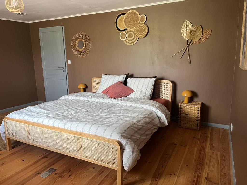 a bedroom with a large bed with white sheets and red pillows at Las Mijeannos in Cazalrenoux