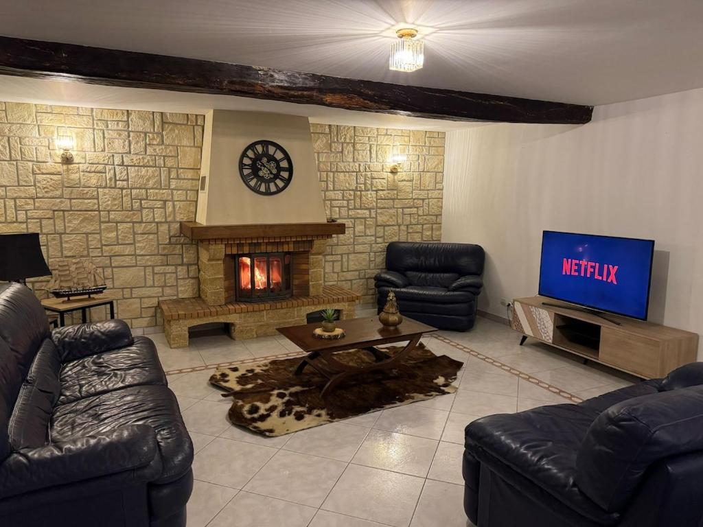 a living room with couches and a tv and a fireplace at Gîte Baytso in Auge