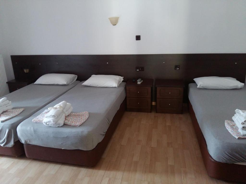 two twin beds in a room with wooden floors at Anna Studios in Mariaí
