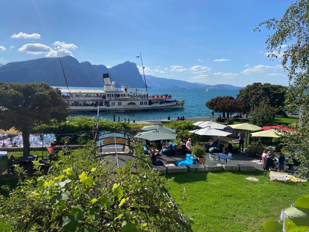 a cruise ship in the water with people sitting under umbrellas at BnB Villa Kapellmatt - Seezugang, Bio-Frühstück, SUP am Rigi in Vitznau