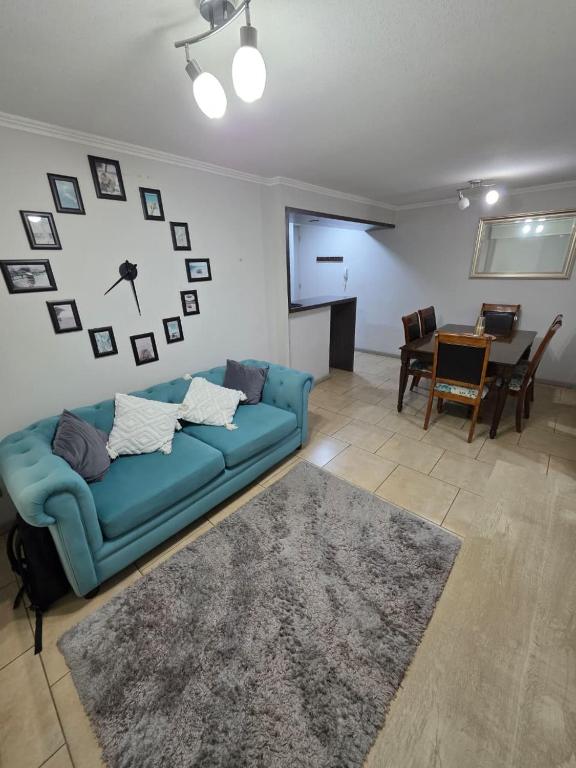 a living room with a blue couch and a table at Comfort, Safety, and Connectivity in Chillán