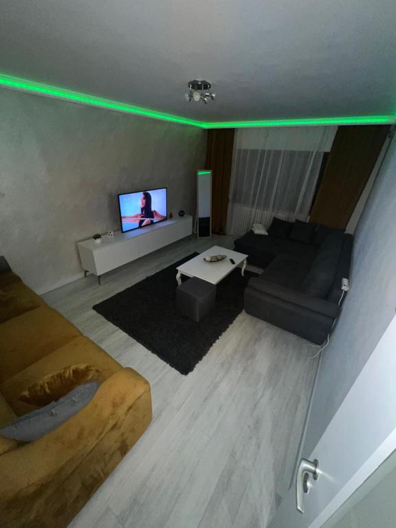 a living room with a couch and a tv with green lights at Relax Loft in Oradea