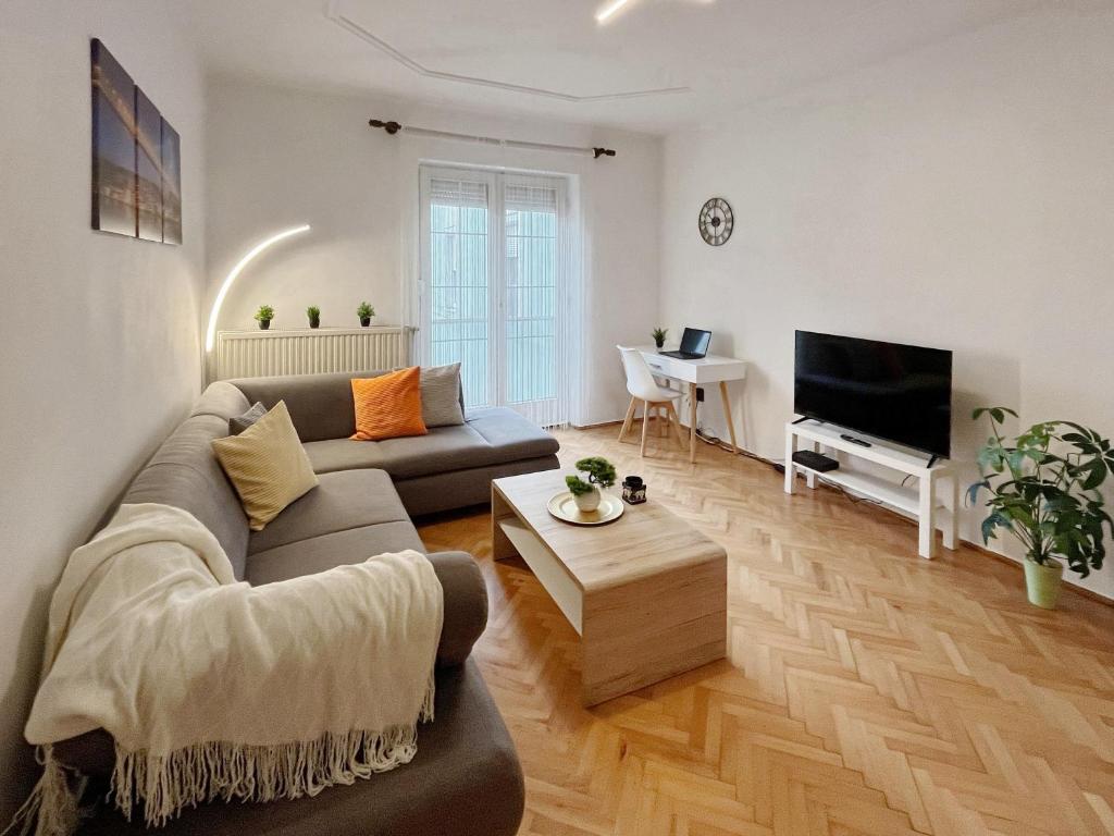 a living room with a couch and a tv at Home4You Szombathely in Szombathely