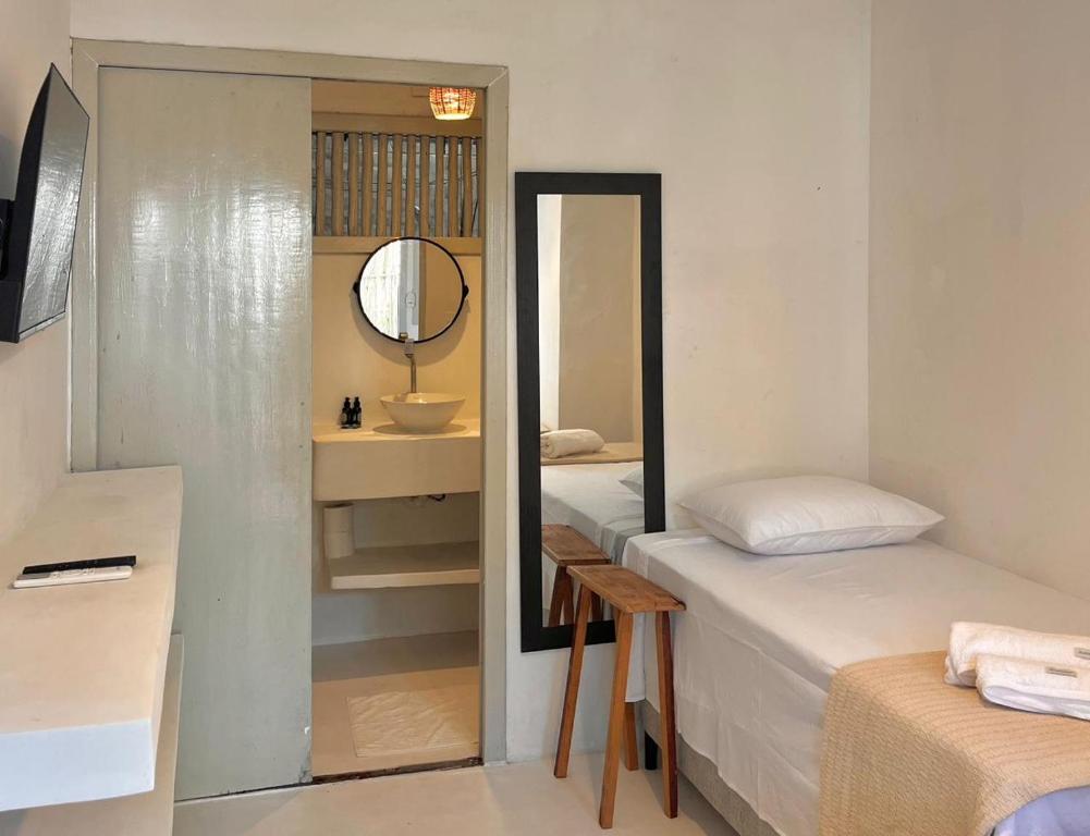 una camera con due letti, uno specchio e un lavandino di Pousada Tamuré a Porto Seguro