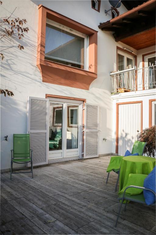 a patio with green chairs and a building at HäuslmaierS Urlaubswohnung in Siegsdorf