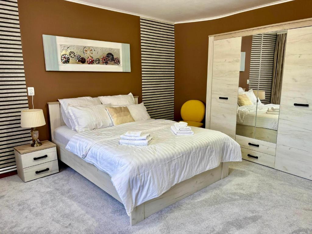 a bedroom with a large bed with white sheets at Casa Fraga in Beiuş