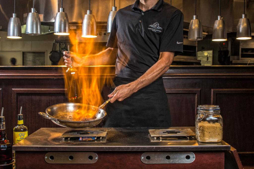 a man in a kitchen preparing food in a bowl at Carnegie Hotel & Spa in Johnson City