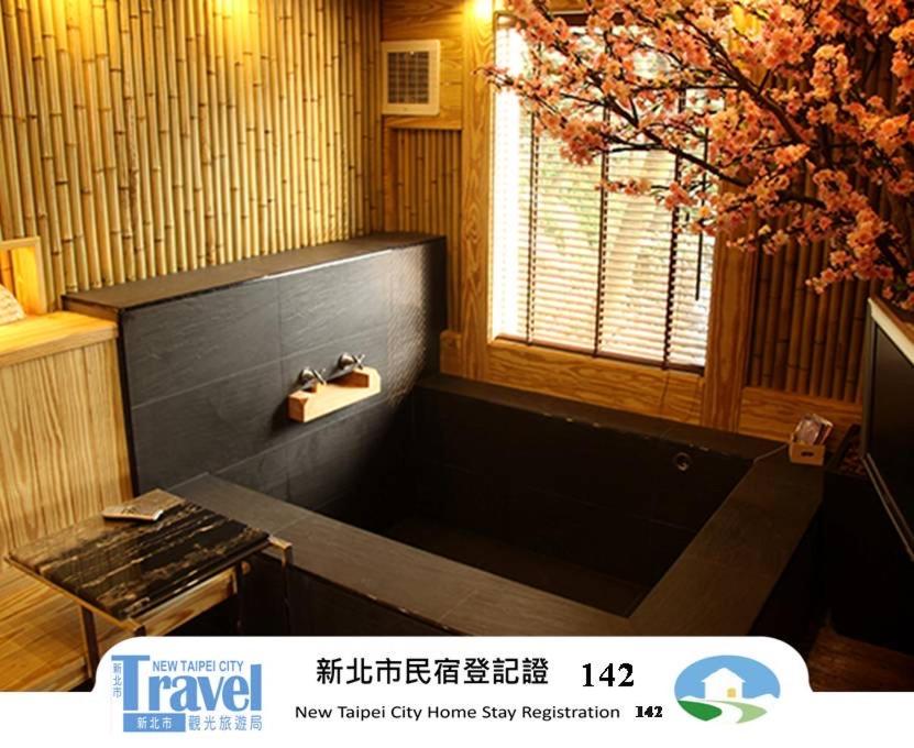 a bathroom with a bath tub and a window at Shanhai Guan B&B in Ruifang