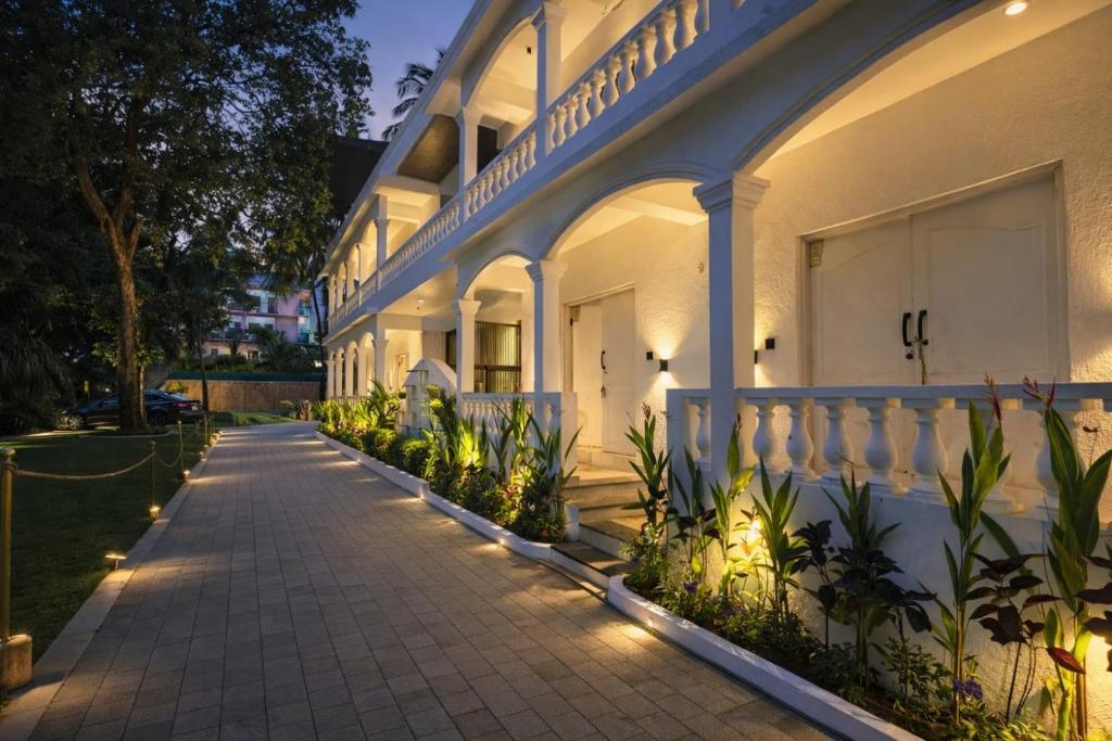 a white building with lights on a sidewalk at White Coco Luxury Villas, Private Pool, North Goa in Baga
