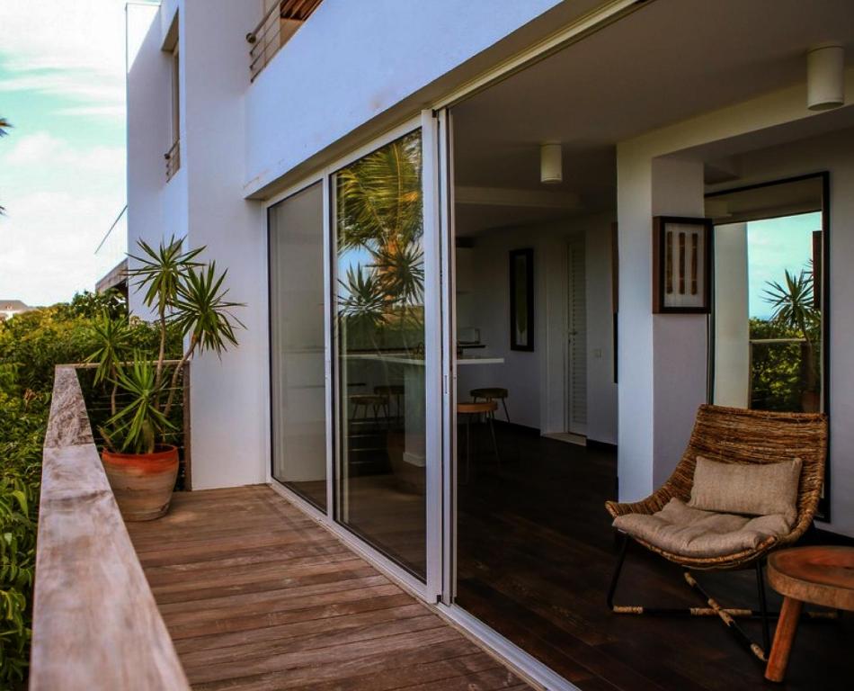 balcone con porte scorrevoli in vetro e sedia di Tropical paradise 