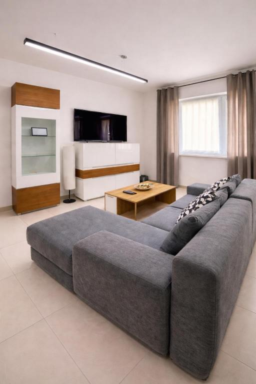 a living room with a large couch and a table at Zielone Apartamenty Katowice Chorzów in Chorzów