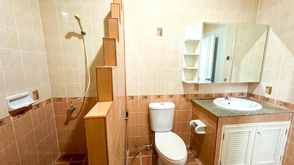 a bathroom with a toilet and a sink and a mirror at Soulful Stay Phuket -Distant Seaview and Mountain View Retreat, Patong in Patong Beach
