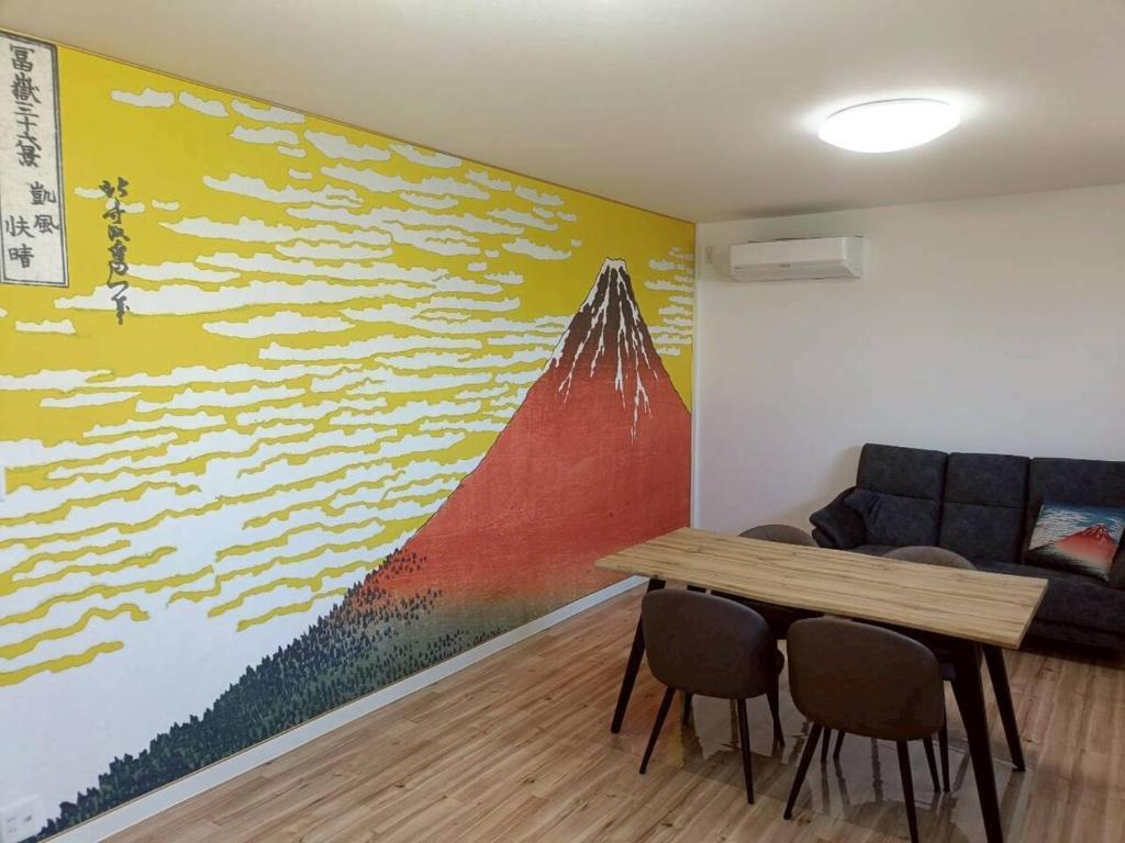 a room with a couch and a table and a painting at つるふく in Misaki