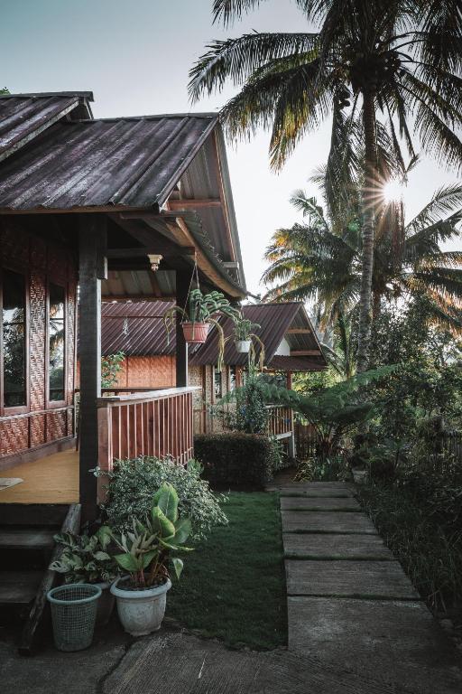 a house with a porch and a palm tree at Kurni's Cabin in Sapit