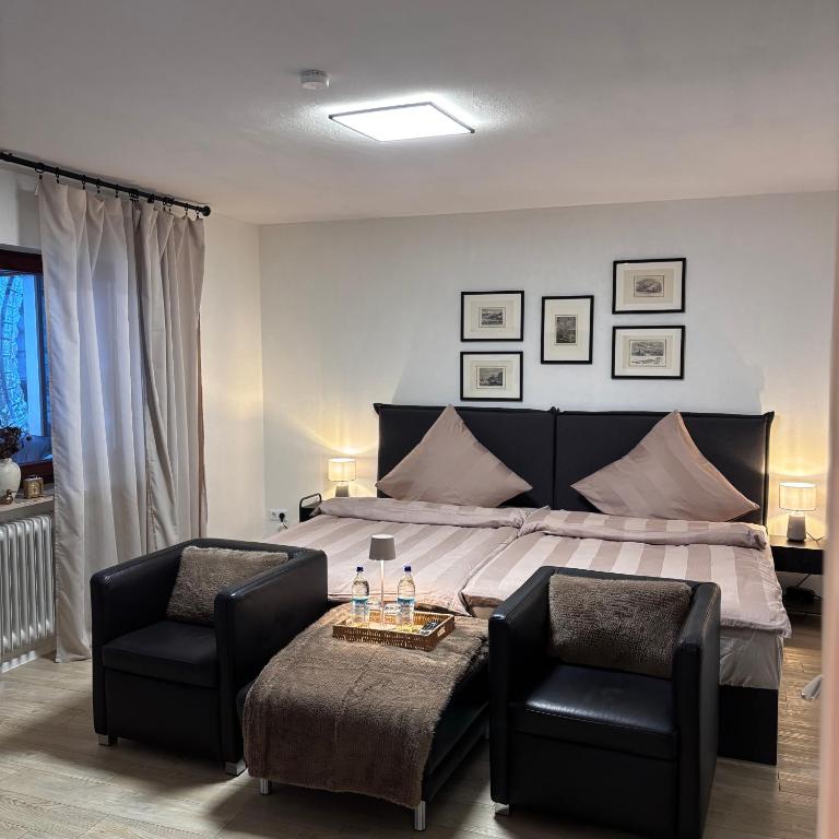 a bedroom with a large bed and two chairs at Waldblick Glatt in Sulz am Neckar