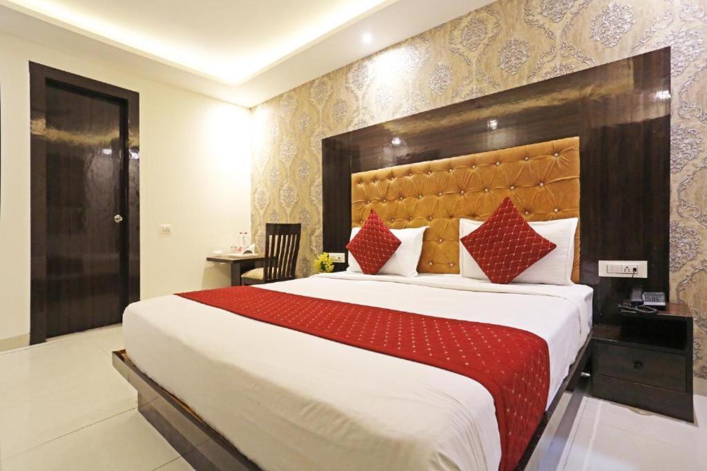 a bedroom with a large bed with a red blanket at Comfy Stay Hotels 2nd Floor in New Delhi