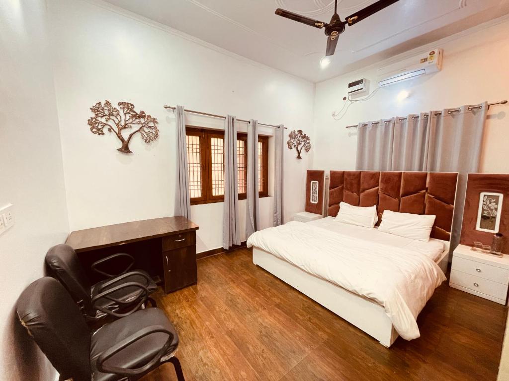 een slaapkamer met een bed, een bureau en een stoel bij Stayble Homestay in Dehradun