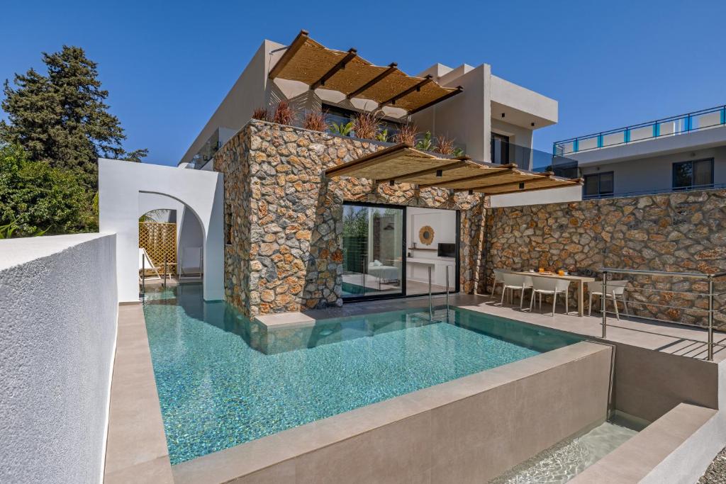 a villa with a swimming pool and a house at Avaton Boutique Suites in Vrachonisída touArchangélou